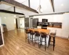 Kitchen with butcher block counters, white cabinetry, a center island with sink, light hardwood / wood-style flooring, and appliances with stainless steel finishes