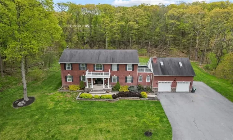 View of front of property with a garage, a front lawn, and a porch