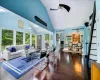 Living room featuring ceiling fan, dark hardwood / wood-style flooring, and high vaulted ceiling