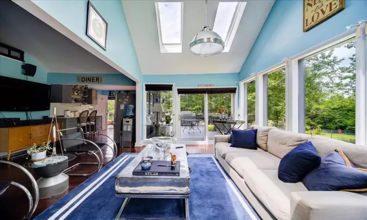 Sunroom / solarium with lofted ceiling with skylight