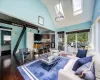 Living room featuring a skylight, high vaulted ceiling, and dark hardwood / wood-style floors