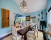 Dining room featuring dark hardwood / wood-style floors, lofted ceiling, and an inviting chandelier