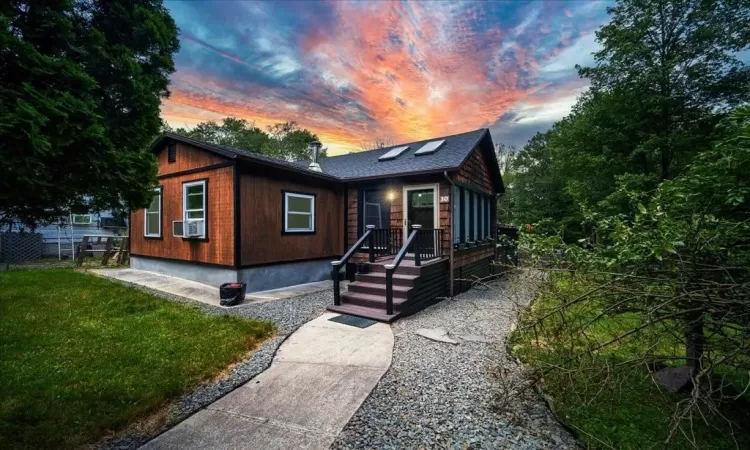 View of front of property with cooling unit and a lawn