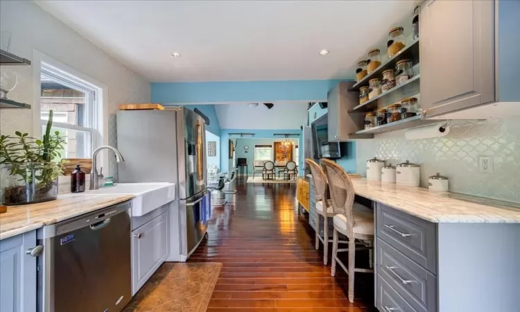 Kitchen featuring gray cabinets, dishwasher, tasteful backsplash, and dark hardwood / wood-style floors