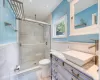 Bathroom featuring a shower with shower door, vanity, tile patterned flooring, and toilet