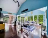 Living room featuring a healthy amount of sunlight, hardwood / wood-style flooring, high vaulted ceiling, and ceiling fan