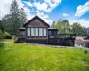 Back of property with a deck and a lawn