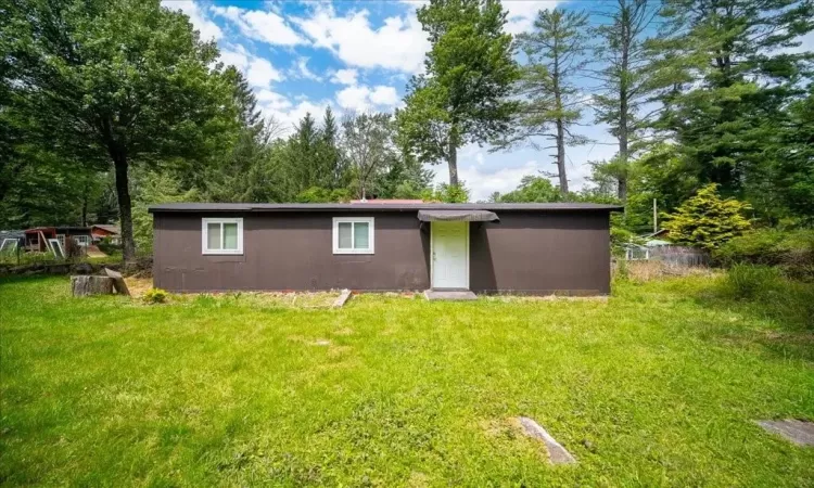 Back of property with a lawn and shed