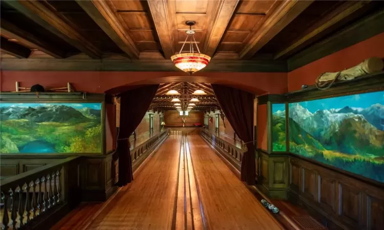 Rec room with beam ceiling, an inviting chandelier, wood ceiling, and wood-type flooring