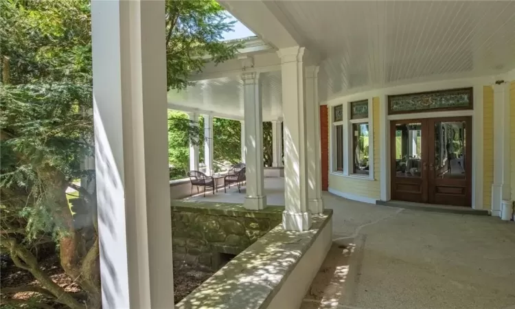 Unfurnished sunroom with french doors and decorative columns