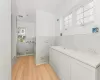 Bathroom with tile walls, shower with separate bathtub, and hardwood / wood-style floors