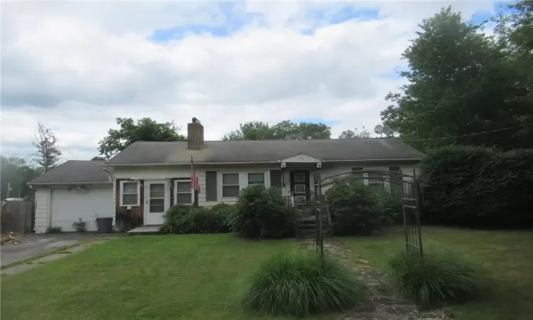 Single story home featuring a garage and a front lawn