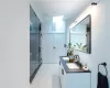 Bathroom featuring a shower with door, wood-type flooring, and double vanity