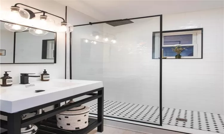 Bathroom featuring sink and tiled shower