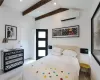 Bedroom featuring an AC wall unit, light wood-type flooring, and vaulted ceiling