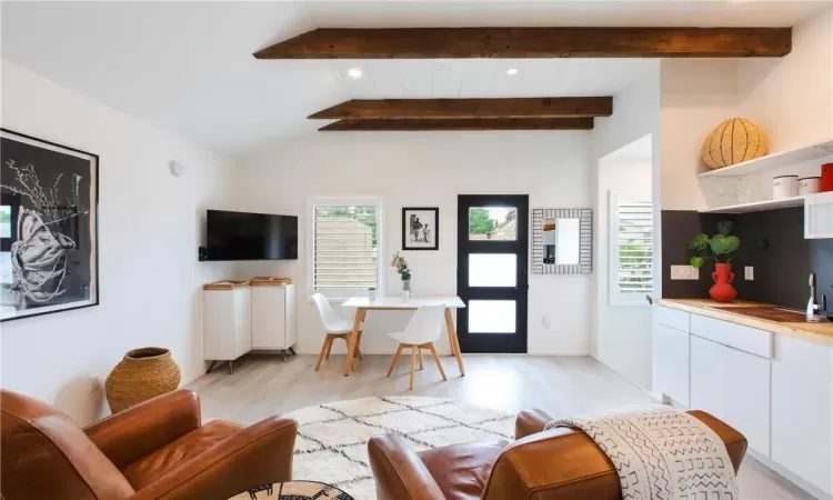 Living room featuring lofted ceiling with beams and light wood-type flooring