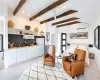 Living room featuring lofted ceiling with beams, light hardwood / wood-style floors, a wall mounted air conditioner, and sink