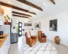 Sitting room with vaulted ceiling with beams, an AC wall unit, and light hardwood / wood-style floors