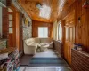 Living area with wooden walls, lofted ceiling, wooden ceiling, and light tile patterned floors