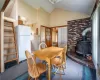 Dining area featuring dark carpet, lofted ceiling, and a wood stove