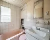 Full bathroom featuring vanity, tile walls, tiled shower / bath combo, and toilet