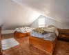 Bedroom with lofted ceiling and dark parquet floors