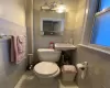 Bathroom with sink, toilet, tile patterned floors, and tile walls