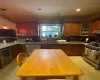 Kitchen with tasteful backsplash, light tile patterned floors, beverage cooler, stainless steel appliances, and sink