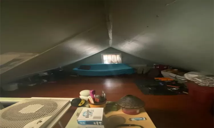 Additional living space featuring wood-type flooring and vaulted ceiling