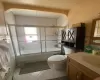 Full bathroom featuring combined bath / shower with glass door, tile patterned floors, toilet, and vanity