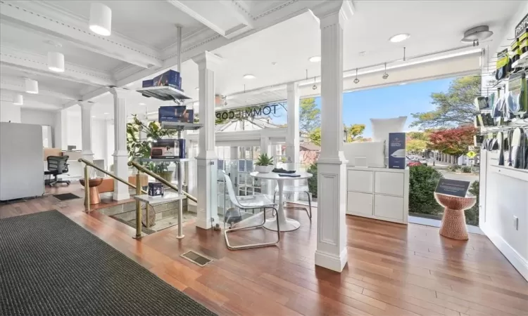 Gym featuring ornamental molding, hardwood / wood-style floors, ornate columns, and coffered ceiling