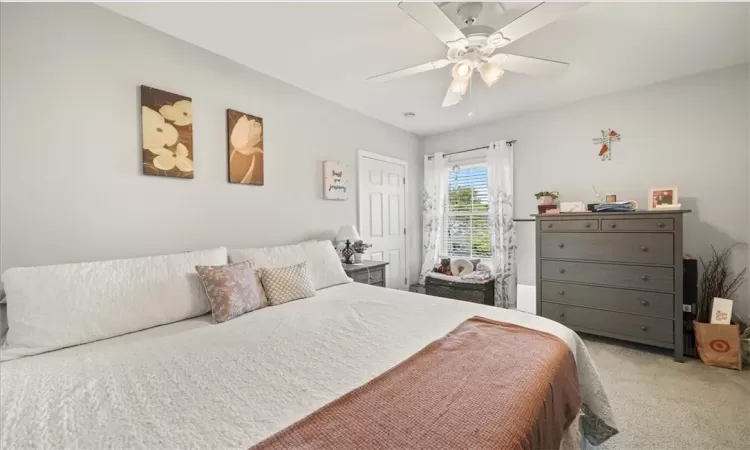 Carpeted bedroom featuring ceiling fan