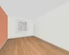 Empty room with vaulted ceiling and light hardwood / wood-style flooring