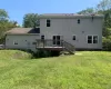 Back of house featuring a wooden deck and a yard