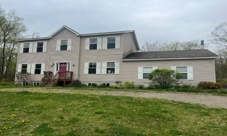 Rear view of house featuring a yard