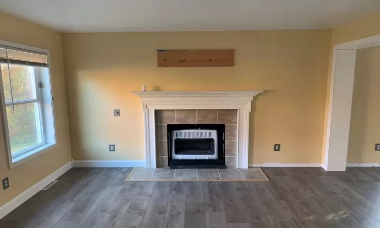 Details featuring hardwood / wood-style floors, a tiled fireplace, and heating unit