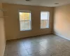 Empty room featuring light tile patterned flooring and plenty of natural light