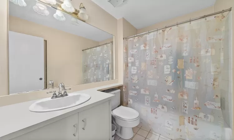 Bathroom featuring toilet, vanity, and tile patterned floors