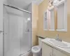 Bathroom with tile patterned flooring, vanity, toilet, and a shower with shower door