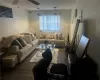 Living room featuring wood walls, ceiling fan, and dark hardwood / wood-style flooring