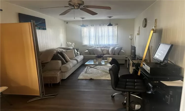 Living room featuring dark wood-type flooring and ceiling fan