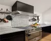 Kitchen with wall chimney range hood, stainless steel range, and light hardwood / wood-style flooring