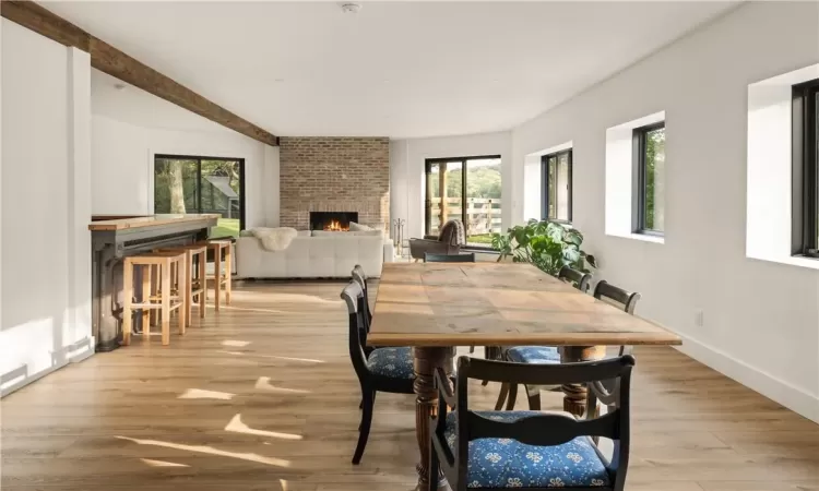 Dining space with a fireplace, bar area, plenty of natural light, and light wood-type flooring