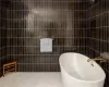 Bathroom featuring a tub, tile patterned floors, and tile walls