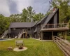 Rear view of property with a patio, a yard, a fire pit, and a wooden deck