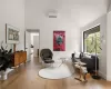 Sitting room featuring wood-type flooring, an AC wall unit, and high vaulted ceiling