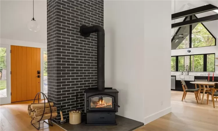 Room details featuring a wood stove, hardwood / wood-style flooring, and sink