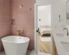 Bathroom with tile walls, a washtub, wood-type flooring, and vanity