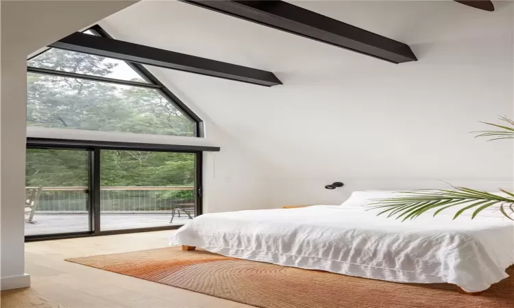 Bedroom with high vaulted ceiling, beam ceiling, light hardwood / wood-style floors, and access to exterior