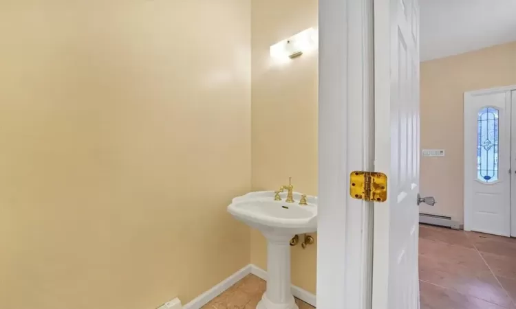 Bathroom featuring tile patterned floors and a baseboard heating unit